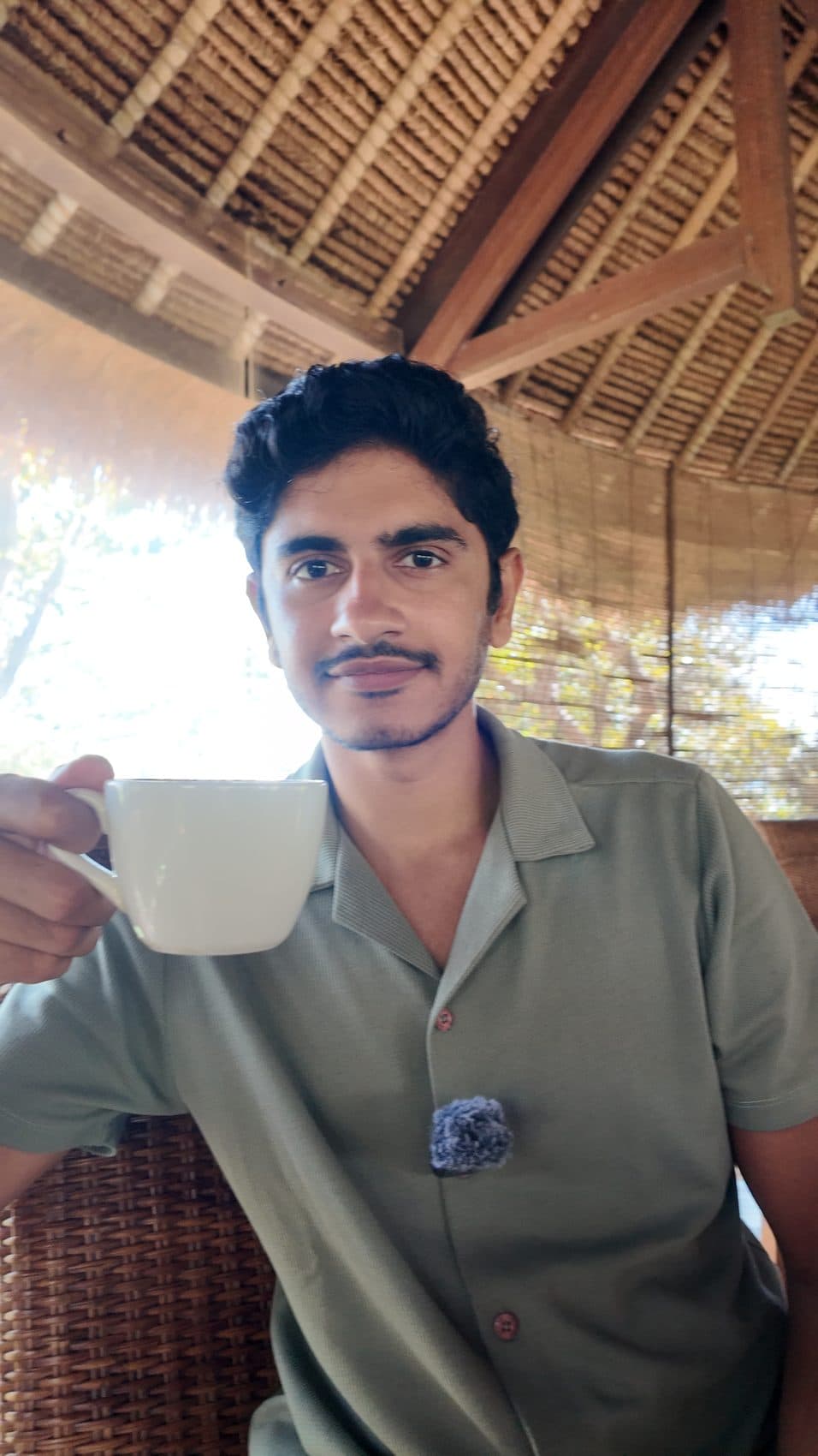 Raising a coffee cup at a bamboo cafe